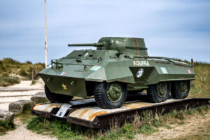 M8 Greyhound, a light armored reconnaissance vehicle of the 2nd Armored Division. The vehicle bears the name "KOUFRA," an allusion to the famous Battle of Kufra in Libya, where Leclerc's troops won a significant victory in 1941.